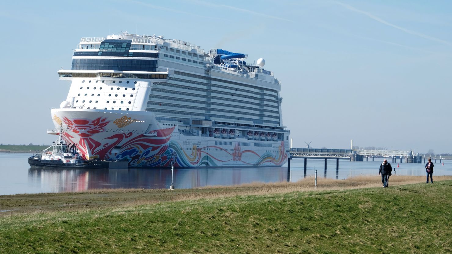 Spectators look on as the "Norwegian Joy" cruise ship, previously named "Norwegian Bliss", makes its way over the river Ems near Emden, northern Germany, on March 27, 2017.
The ship of the Norwegian Cruise Line, that was built at the Meyer Werft shipyard in Papenburg, northern Germany, is made ready to enter service. Final technical and nautical tests are due to be carried out during the following days on the North Sea. / AFP PHOTO / PATRIK STOLLARZ        (Photo credit should read PATRIK STOLLARZ/AFP via Getty Images)