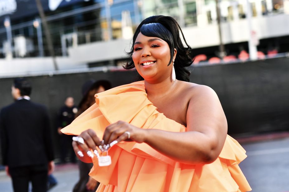 Lizzo arrives at the Microsoft Theater for the 2019 American Music Awards, pairing her off-shoulder gown with a white micro-purse. Scroll through the gallery to see more looks from Sunday evening's red carpet. 