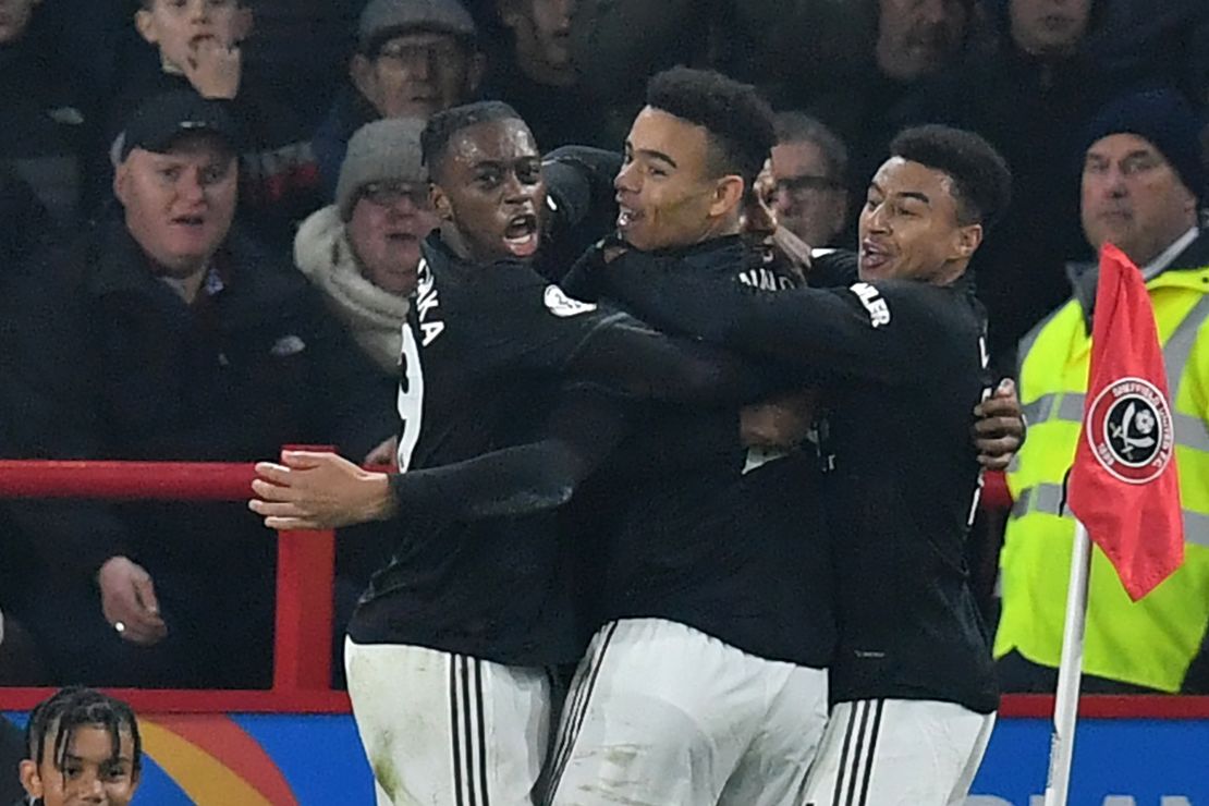 Marcus Rashford, who is hidden, celebrates with teammates after scoring Manchester United's third goal.