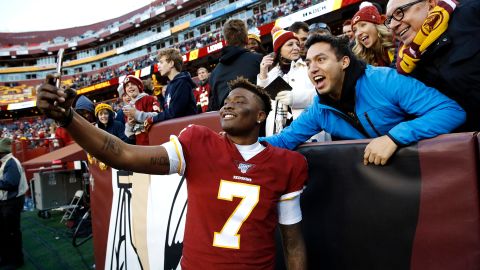 Washington Redskins quarterback Dwayne Haskins takes selfies with fans at the end of Sunday's game against the Detroit Lions.