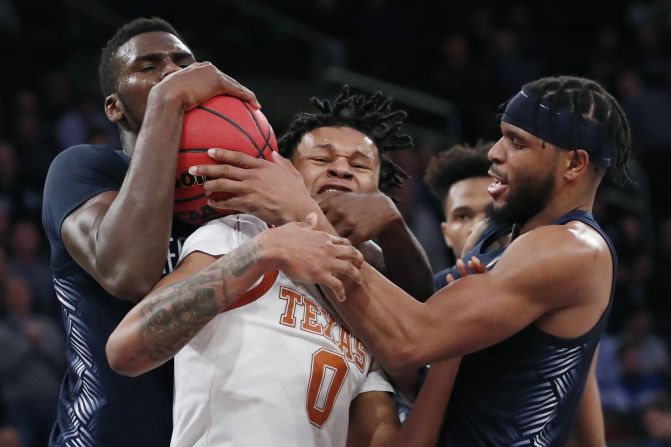 Georgetown players Qudus Wahab, left, and Jagan Mosely battle for a ball with Texas' Gerald Liddell on Thursday, November 21.