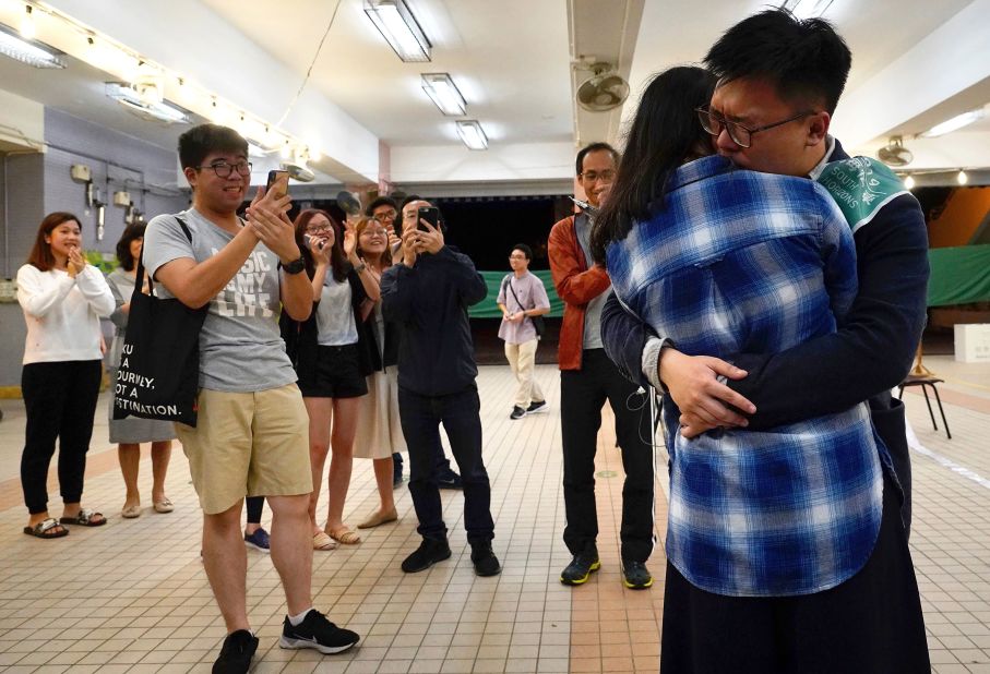Pro-democracy candidate James Yu hugs his girlfriend after winning his seat in district council elections, early November 25.