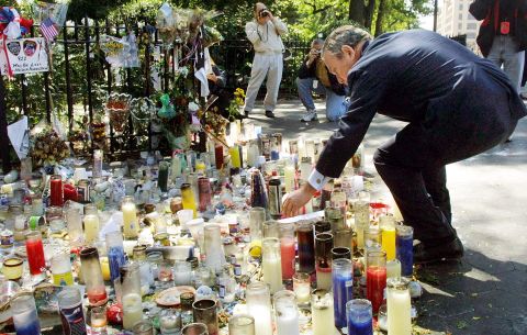 Bloomberg places a candle at a World Trade Center memorial in September 2001.