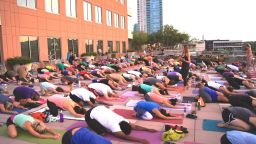 A yoga class on Whole Foods Market flagship store's rooftop plaza, Lamar St., Austin, TX, 2019.