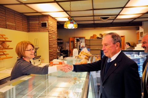 Bloomberg shakes hands with coffee shop owner Susan O'Donnell while visiting Dover, New Hampshire, in January 2019.