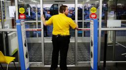 An employee prepares to open the entrance doors to a Best Buy Co. store ahead of Black Friday in Chesapeake, Virginia, U.S., on Thursday, Nov. 26, 2015. In 2011, several big U.S. retailers moved their opening times to midnight; in 2012, Wal-Mart crossed the Rubicon and opened its stores at 8 p.m. on Thanksgiving Day. But after last year's Thanksgiving weekend retail sales fell 11 percent from the year before while overall holiday sales rose, some retailers have been reconsidering. Photographer: Luke Sharrett/Bloomberg via Getty Images
