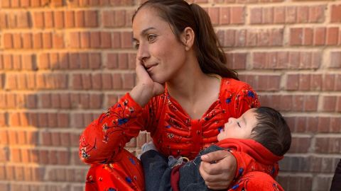 A woman sits with a young child at a shelter for people fleeing war in northern Syria.