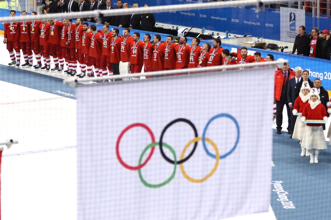 Russian athletes competing under  a neutral banner look on as the Olympic flag is raised during the medal ceremony at PyeongChang 2018.