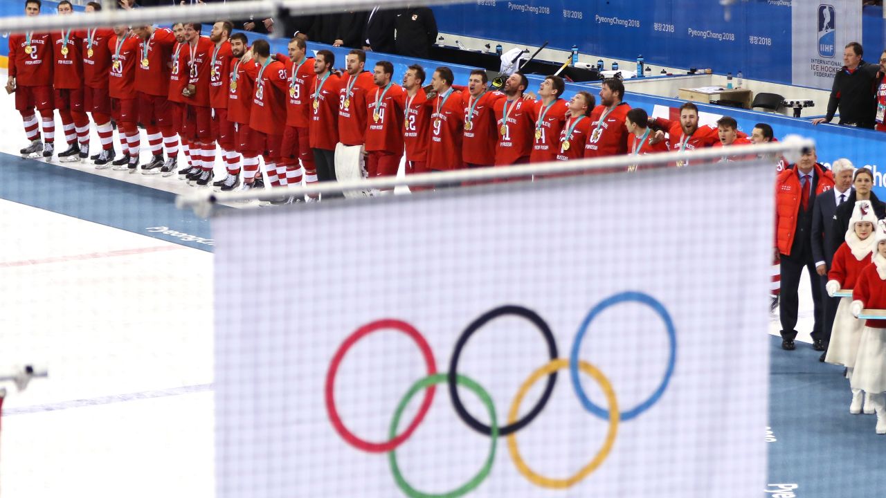Russian athletes competing under  a neutral banner look on as the Olympic flag is raised during the medal ceremony at PyeongChang 2018.