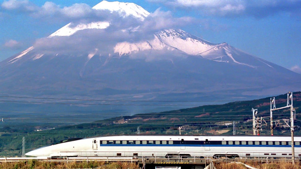 A Shinkansen train speeds past Mount Fuji.