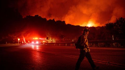 A firefighter crosses Highway 154 while battling the Cave Fire in Los Padres National Forest.