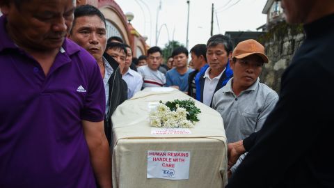 Relatives carry the casket bearing the body of migrant Nguyen Van Hung on arrival in Hanoi on November 27, 2019.