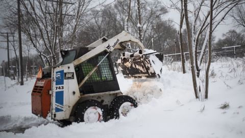 A man plows snow Wednesday after a blizzard struck Minneapolis.