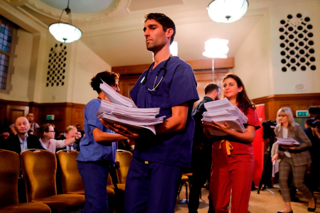 NHS workers hand out documents on the Conservative government's UK-US trade talks during a a press conference by the opposition Labour party leader Jeremy Corbyn.