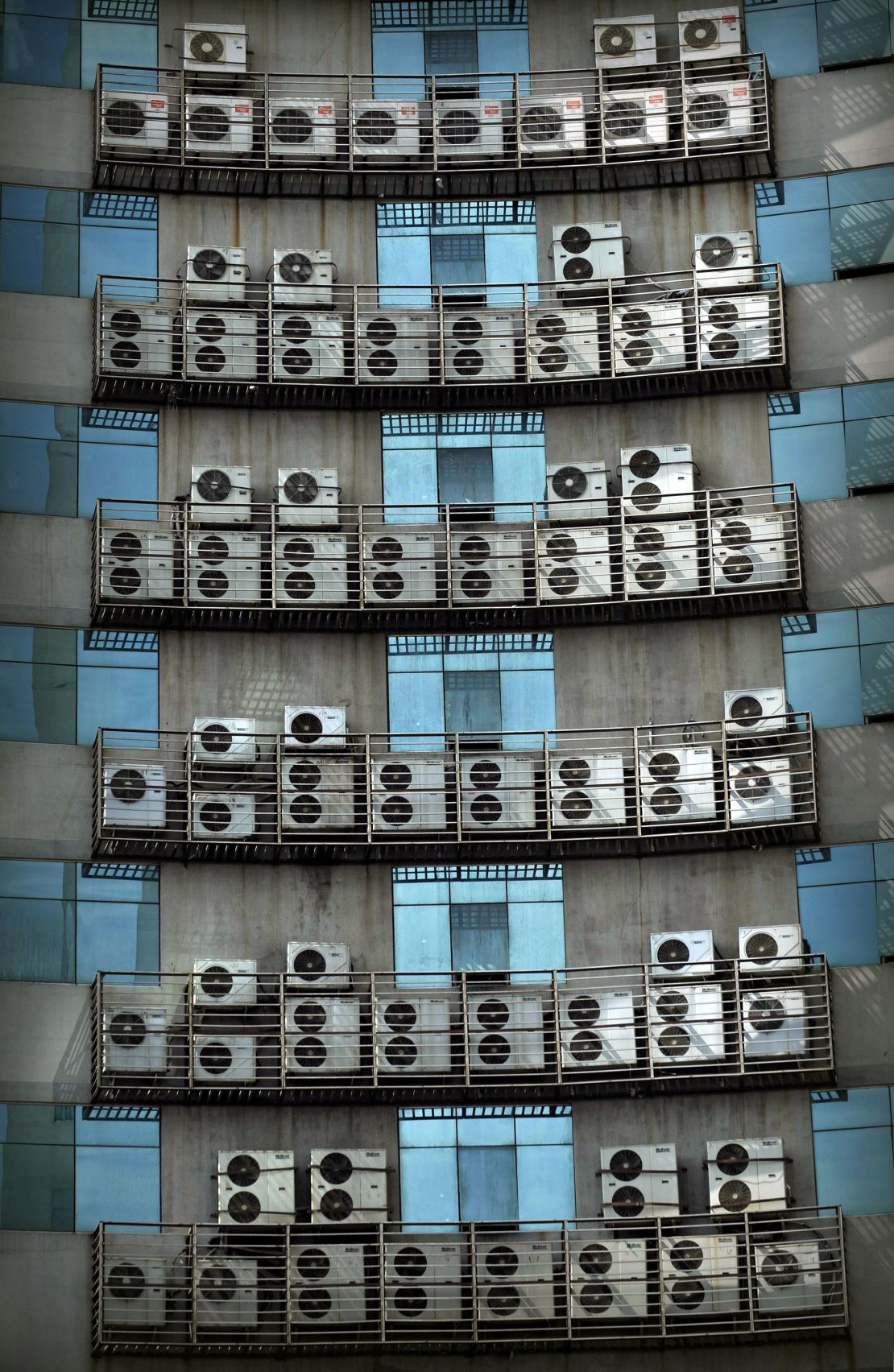 Air conditioners hang on the wall of an office building in Fuzhou, Fujiang Province of China. 