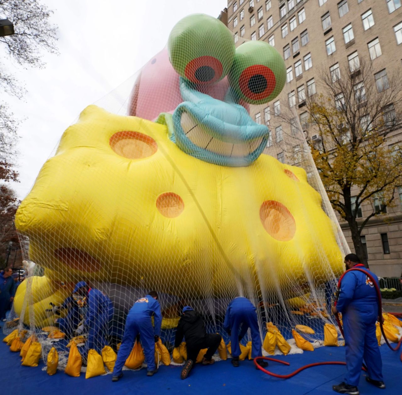 A "SpongeBob SquarePants" balloon is kept under a net after being inflated.