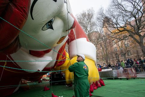 A man works near the Ronald McDonald balloon.