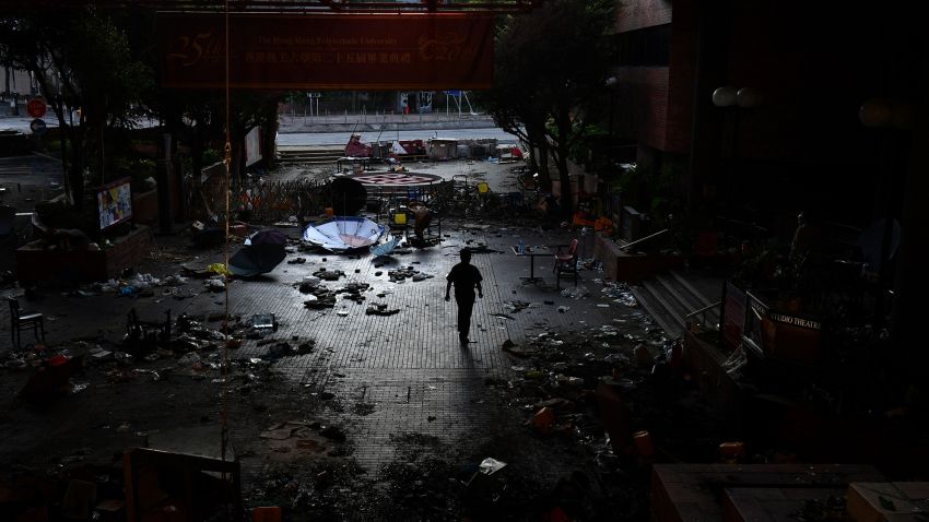 A man walks past debris littering the entrance at the Hong Kong Polytechnic University campus in the Hung Hom district of Hong Kong on November 27, 2019, over a week after police surrounded the building while protesters were still barricaded inside. - Teams at one of Hong Kong's top universities picked through the chaotic aftermath of a violent occupation by protesters for a second day on November 27 as the school searches for elusive holdouts -- and a way forward for a devastated institution. (Photo by Anthony WALLACE / AFP) (Photo by ANTHONY WALLACE/AFP via Getty Images)