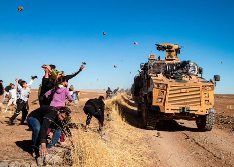 Kurdish demonstrators hurl rocks at a Turkish military vehicle on Friday, November 8, during a joint Turkish-Russian patrol near the town of Al-Muabbadah in the northeastern part of Hassakah on the Syrian border with Turkey. 