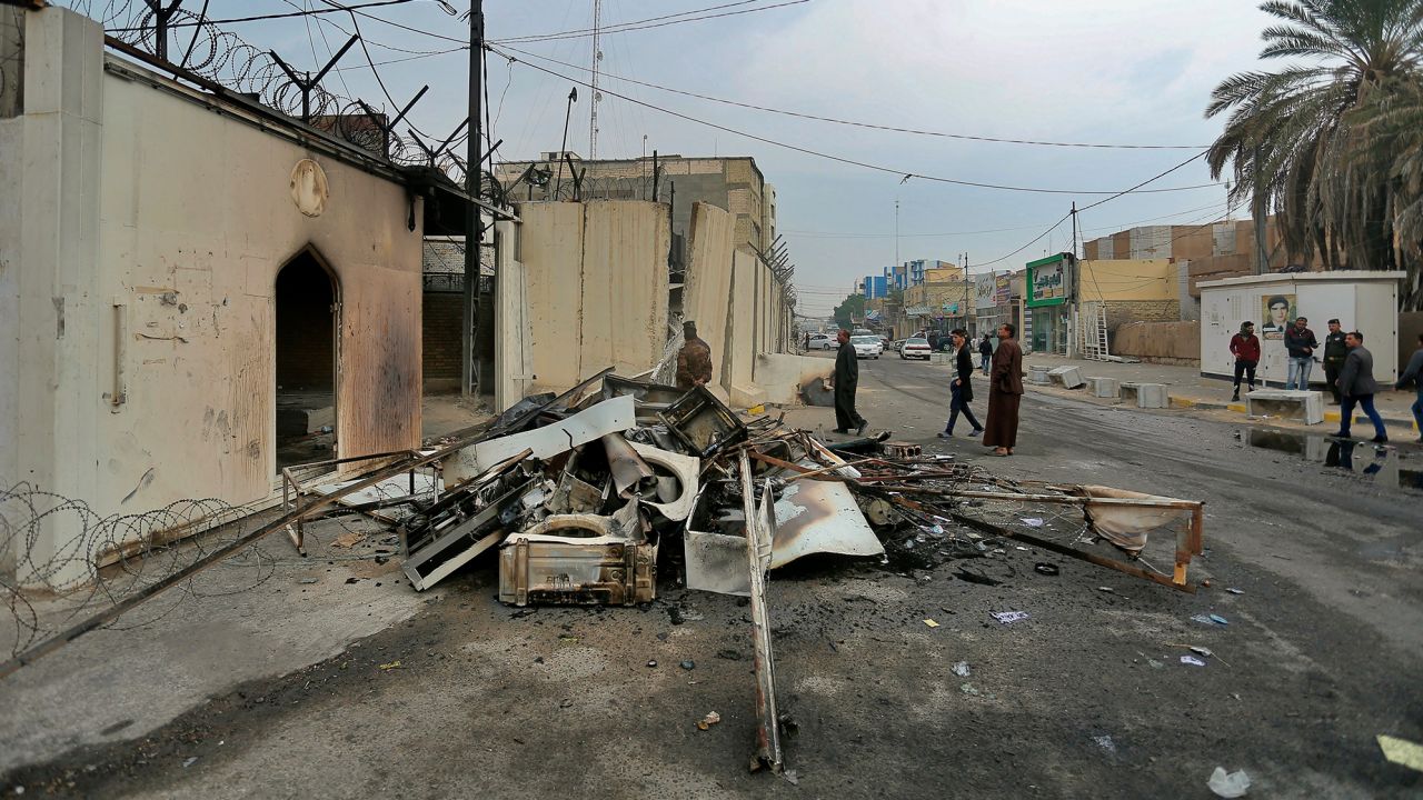 Security forces and civilians gather near the burned Iranian consulate in Najaf on Thursday.