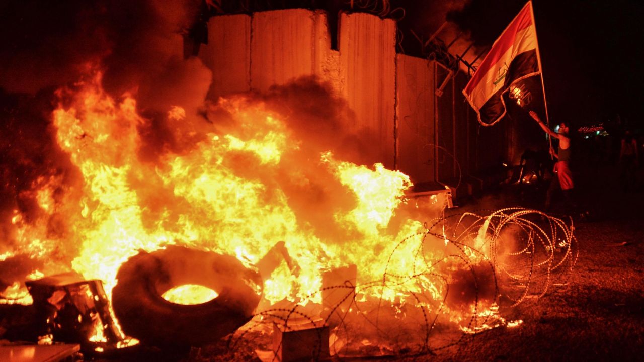 Iraqi demonstrators gather as flames start consuming Iran's consulate in the southern Iraqi holy city of Najaf on November 27, 2019, two months into the country's most serious social crisis in decades.