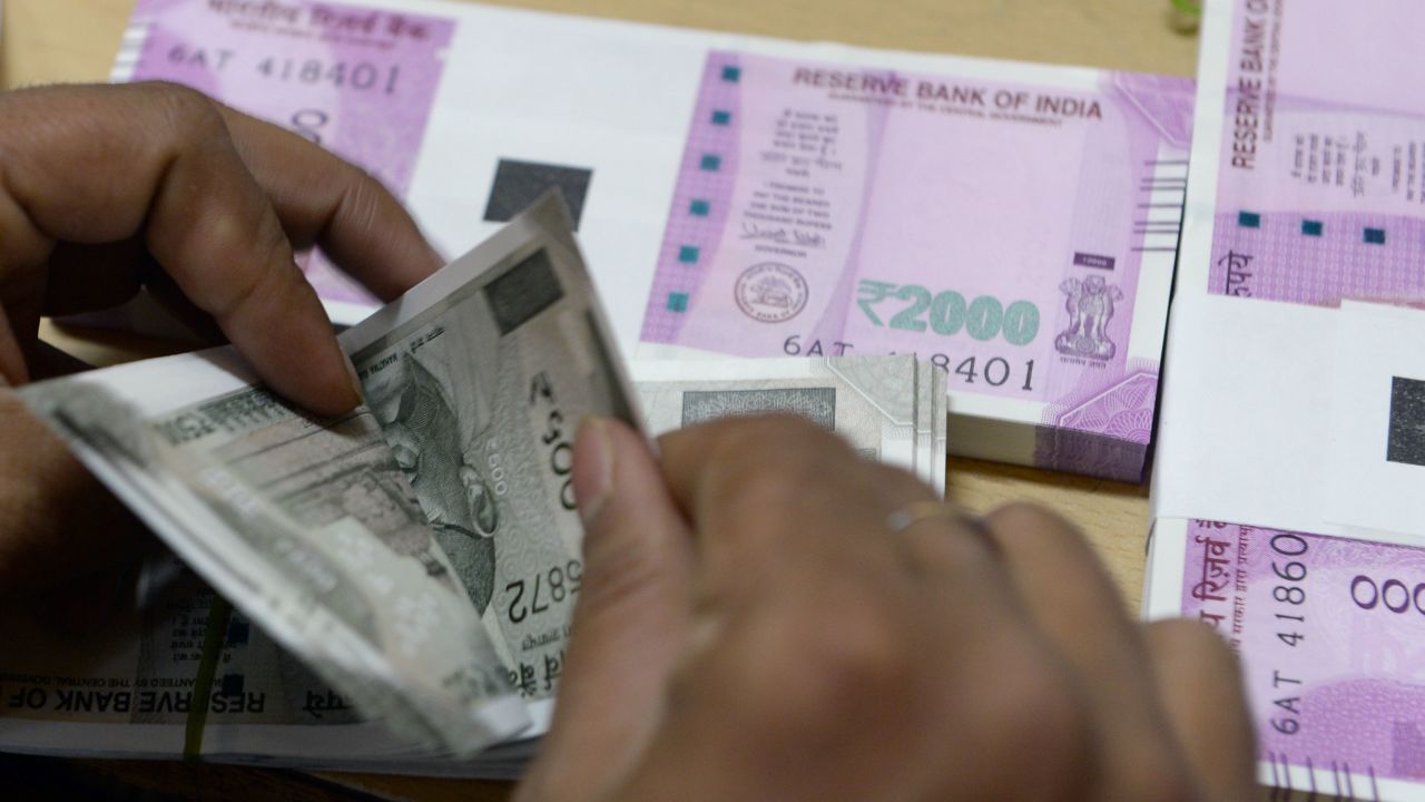 A bank staff member counts Indian 500 rupee notes to give to customers on November 24, 2016.