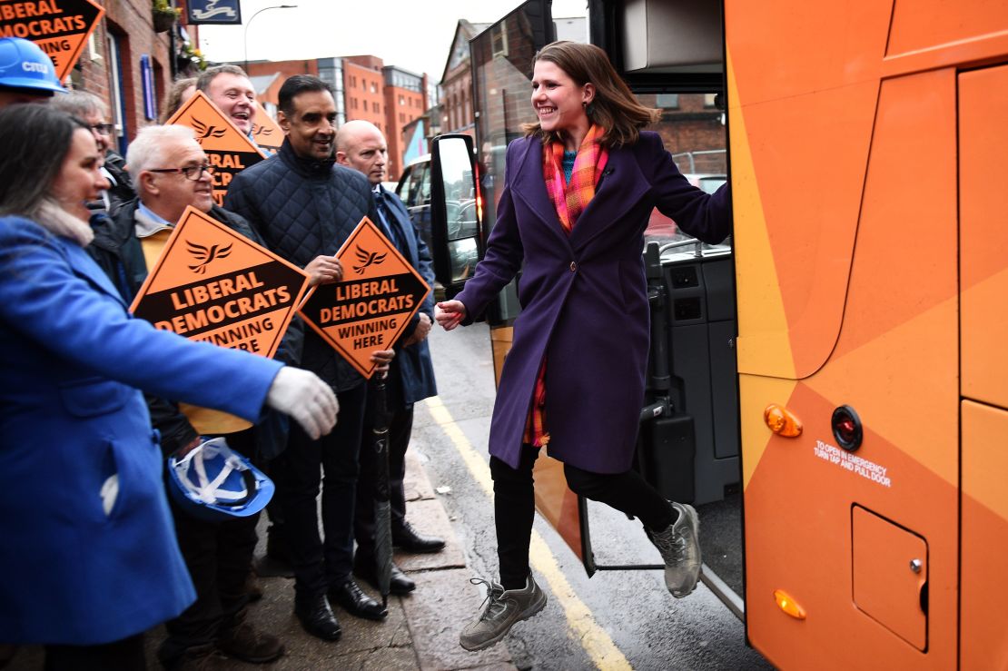 The Liberal Democrats' leader Jo Swinson steps off an orange bus to be greeted by supporters.