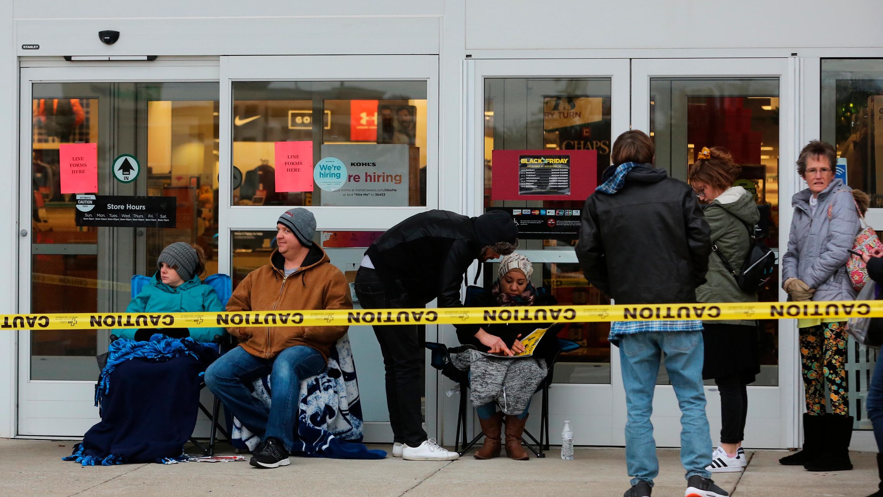 People sit in front of a Kohl's store in Green Township, Ohio.