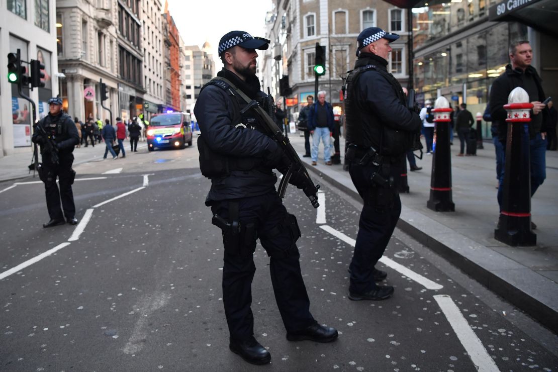 Armed policman stand guard at Cannon Street station in central London, on Friday.