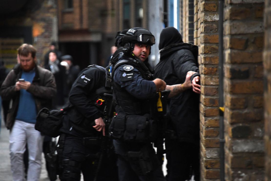 Police apprehend a man in a street on the south side of London Bridge on Friday.
