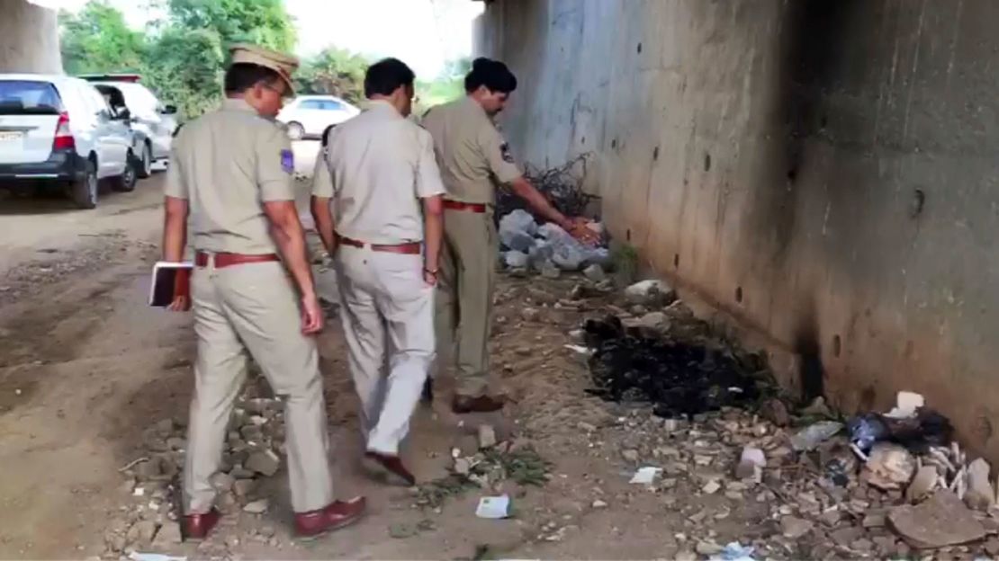 Indian police officers inspect the site where they found the burned body of a 27-year-old woman in an underpass on the outskirts of Hyderabad.