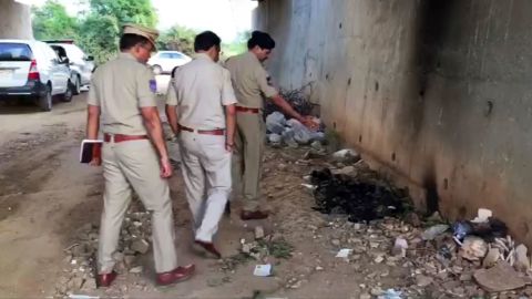 Indian police officers inspect the site where they found the burned body of a 27-year-old woman in an underpass on the outskirts of Hyderabad.