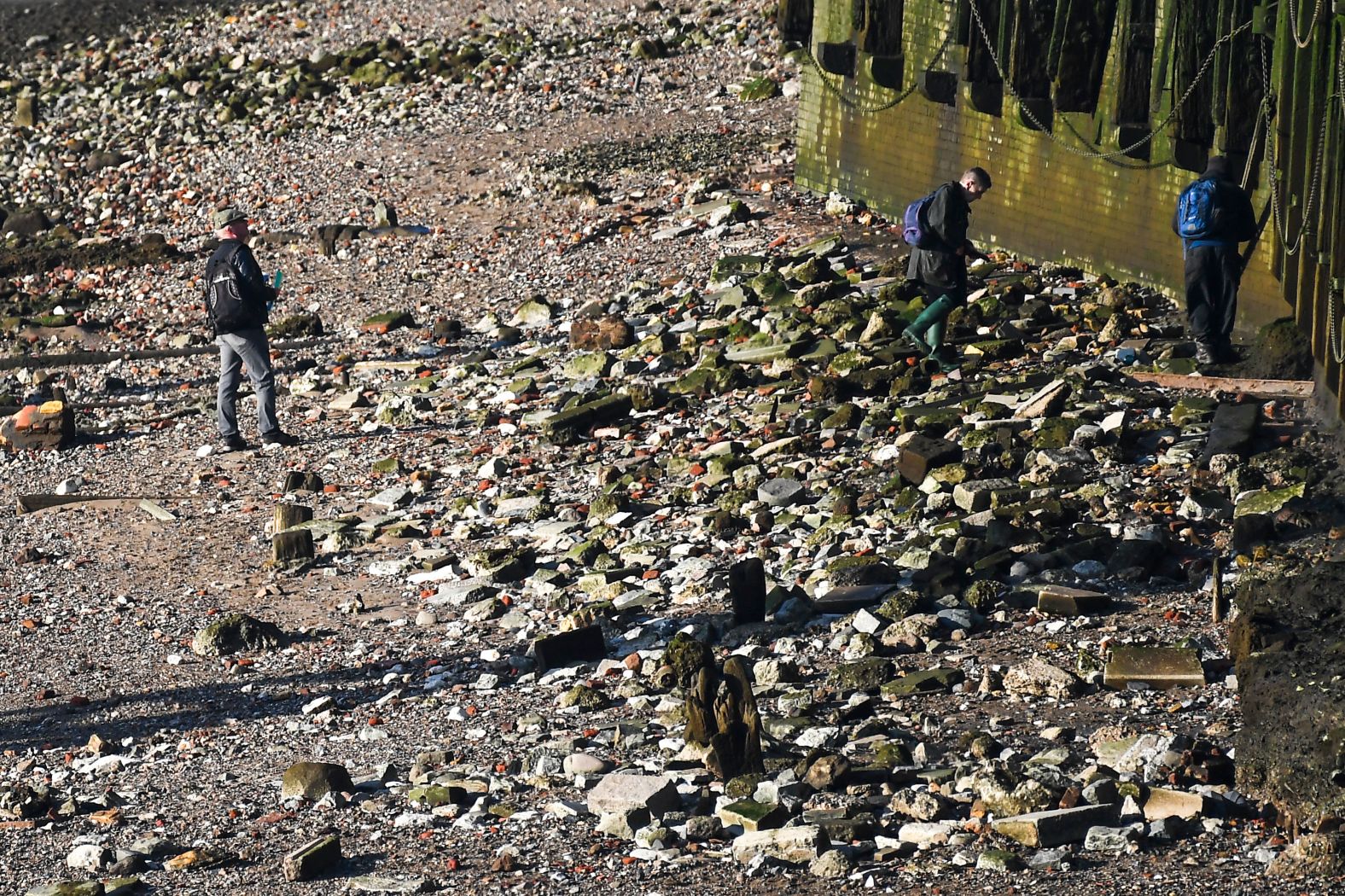 Forensic officers examine the river Thames bank under London Bridge.