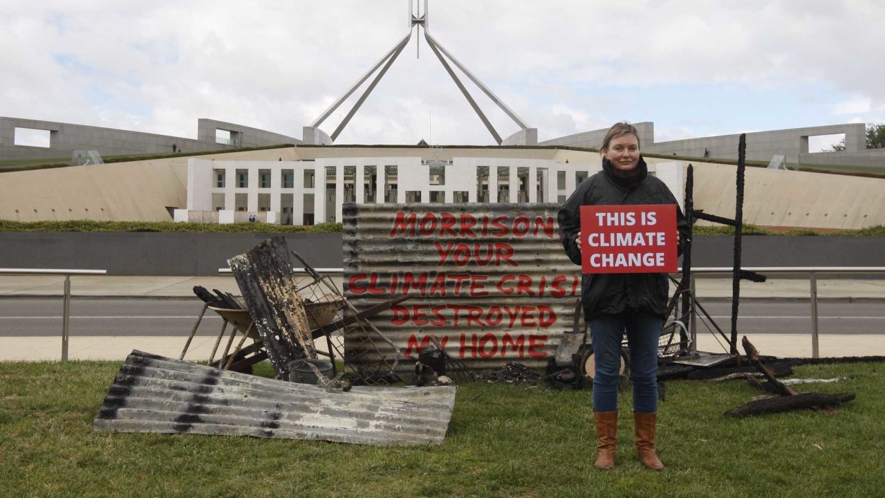 Bushfire survivor Melinda Plesman delivers the message "This is Climate Change" outside Parliament House in Canberra.