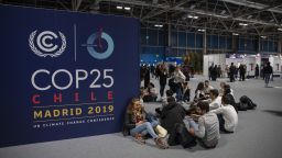 People sit on the ground during the opening day of the COP25 climate conference in Madrid, Spain.