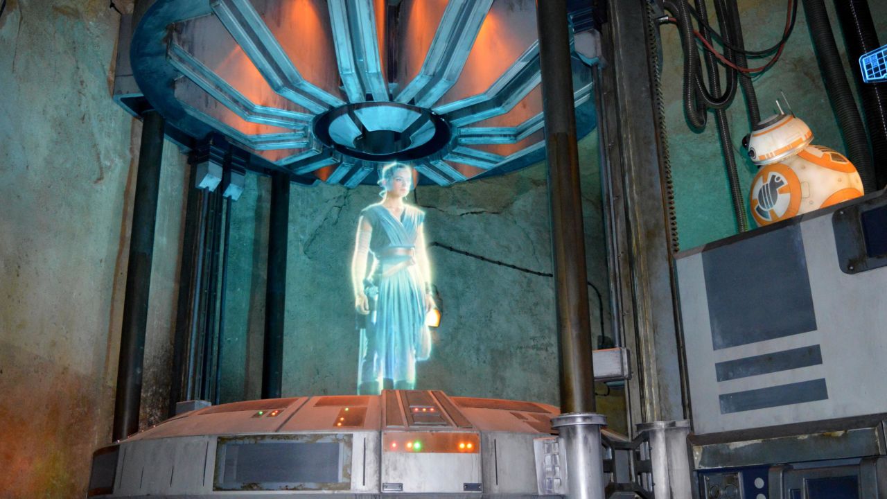 A Rey hologram greets new recruits (ie park guests) inside a makeshift briefing room.