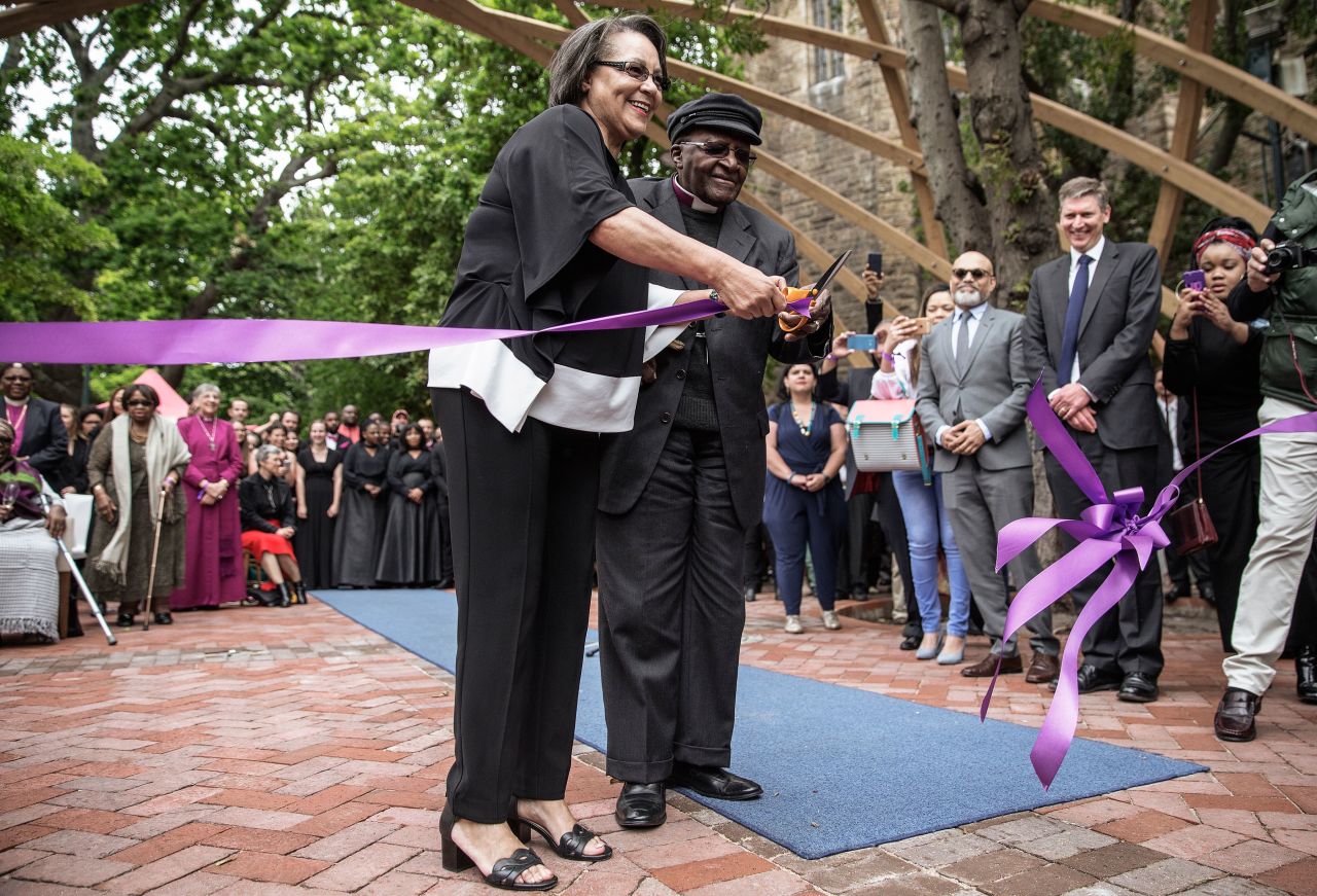 Tutu, accompanied by Cape Town Mayor Patricia de Lille, cuts a ribbon to unveil the "Arch for the Arch" in 2017. The architectural structure commemorates Tutu's life and work and also represents the 14 chapters of the South African constitution.