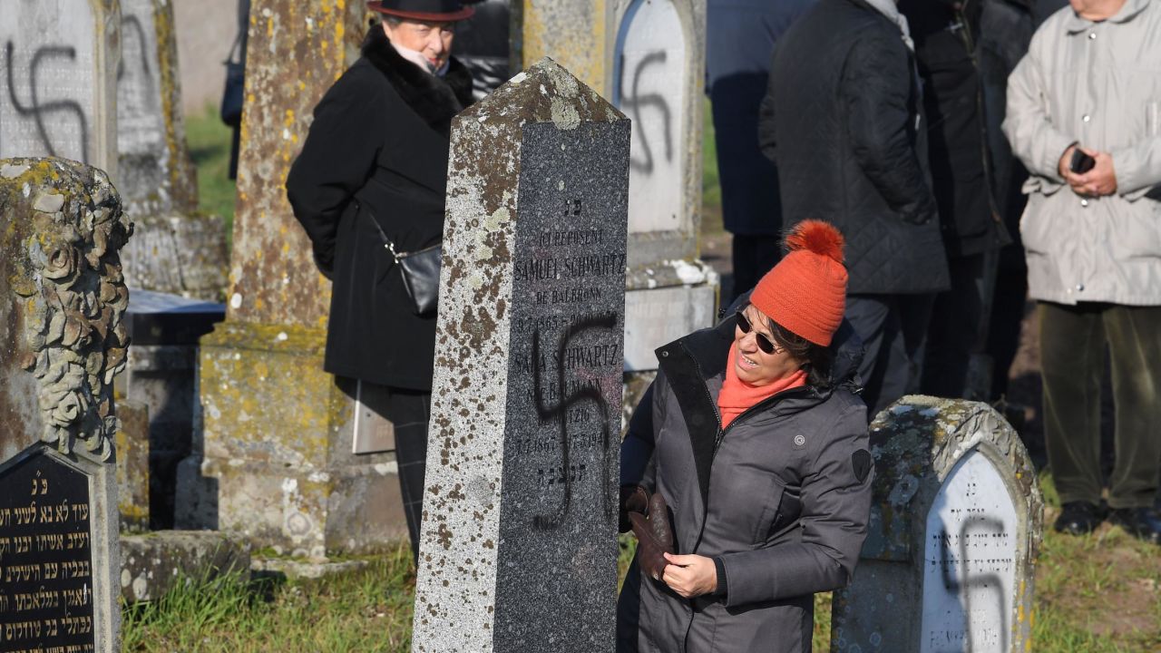 People look at vandalised tombs, on December 4, 2019 at the jewish Westhoffen cemetery near Strasbourg, eastern France, where 107 graves were found vandalised with swastikas and antisemitic inscriptions. (Photo by Patrick HERTZOG / AFP) (Photo by PATRICK HERTZOG/AFP via Getty Images)