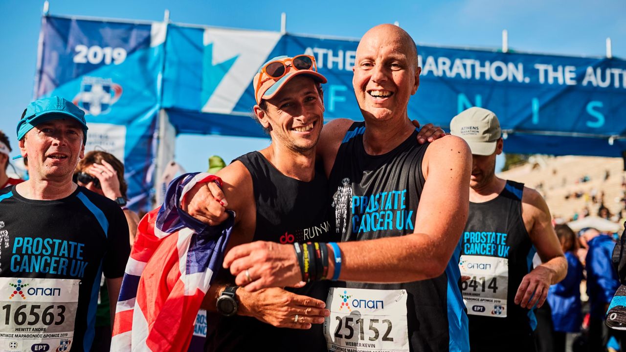 Butter (left) celebrates at the finish line in Athens with close friend Kevin Webber -- the inspiration behind the trip. 