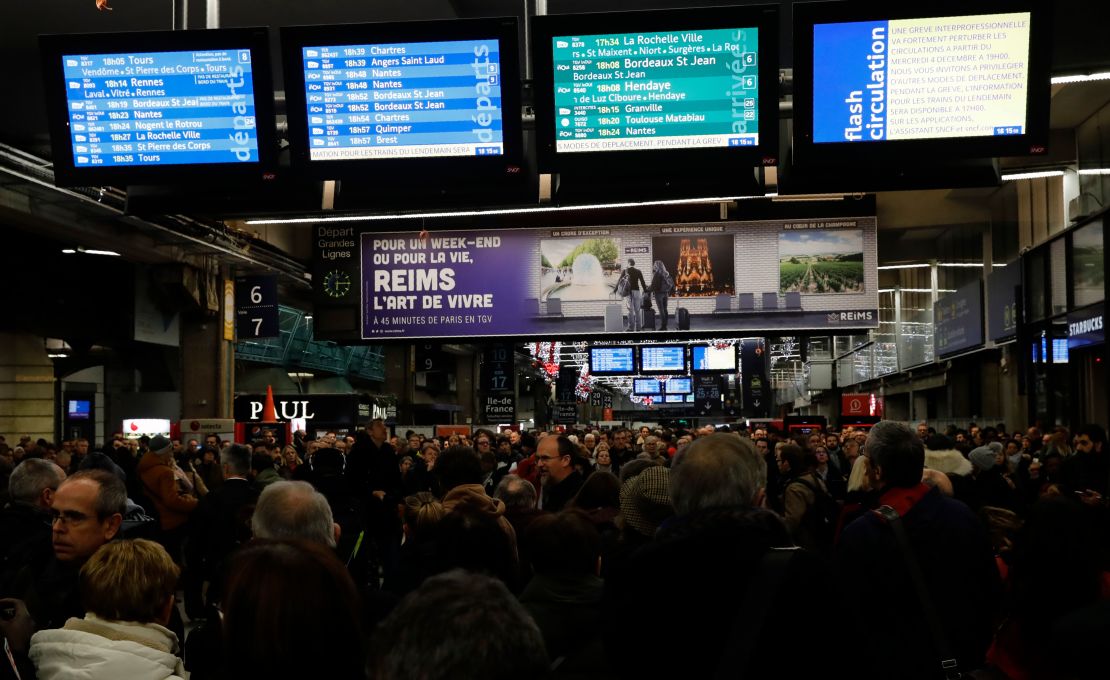 Commuters walk inside Montparnasse train station in Paris on December 4, 2019, on the eve of a national strike over pension reforms.
