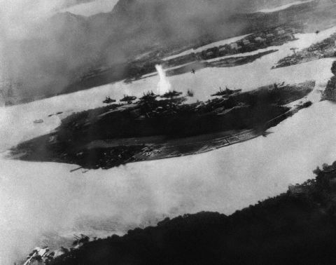 This is believed to be an image of the first bomb on Pearl Harbor; it shows a Japanese plane pulling out of a dive near the explosion.