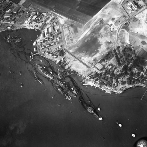 An aerial view of the harbor shows the destruction of the USS California, the USS Maryland, the USS Oklahoma, the USS Tennessee, the USS West Virginia and the USS Arizona.