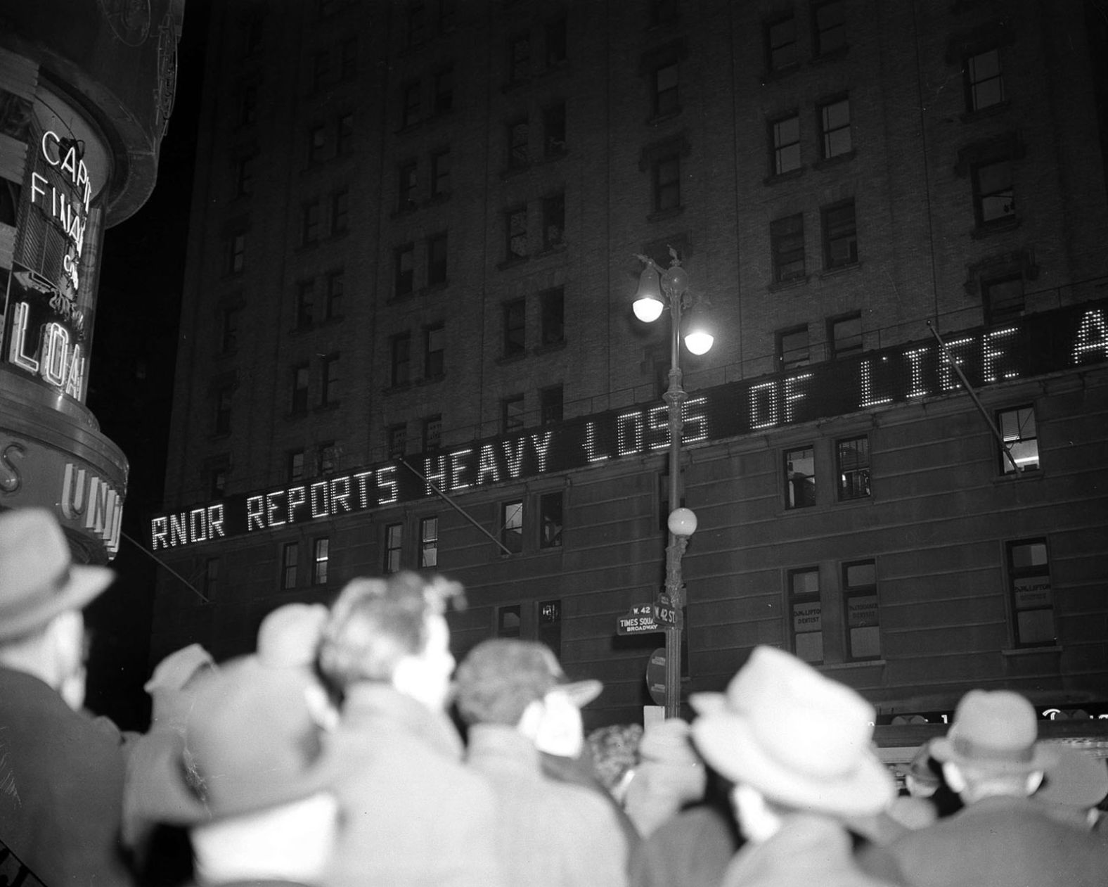 Crowds gather in New York's Times Square as news bulletins about the attack flash across the New York Times building.