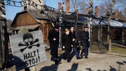 Merkel, Morawiecki and the Auschwitz museum director Piotr Cywinski walk past the "Arbeit Macht Frei" gate in the former Nazi death camp.
