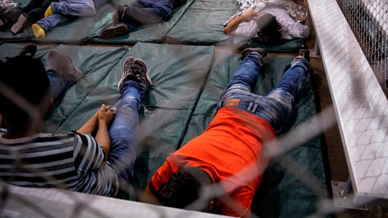 MCALLEN, TEXAS - AUGUST 12:
Men rest on bed pads in the US Border Patrol Central Processing Center in McAllen, Texas on August 12, 2019. Border Patrol officials said that 1,267 people were being held and processed in the facility at the time of the tour.  (Photo by Carolyn Van Houten/The Washington Post via Getty Images)