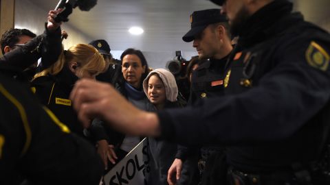 Thunberg is escorted by police on her arrival at Atocha train station in Madrid.