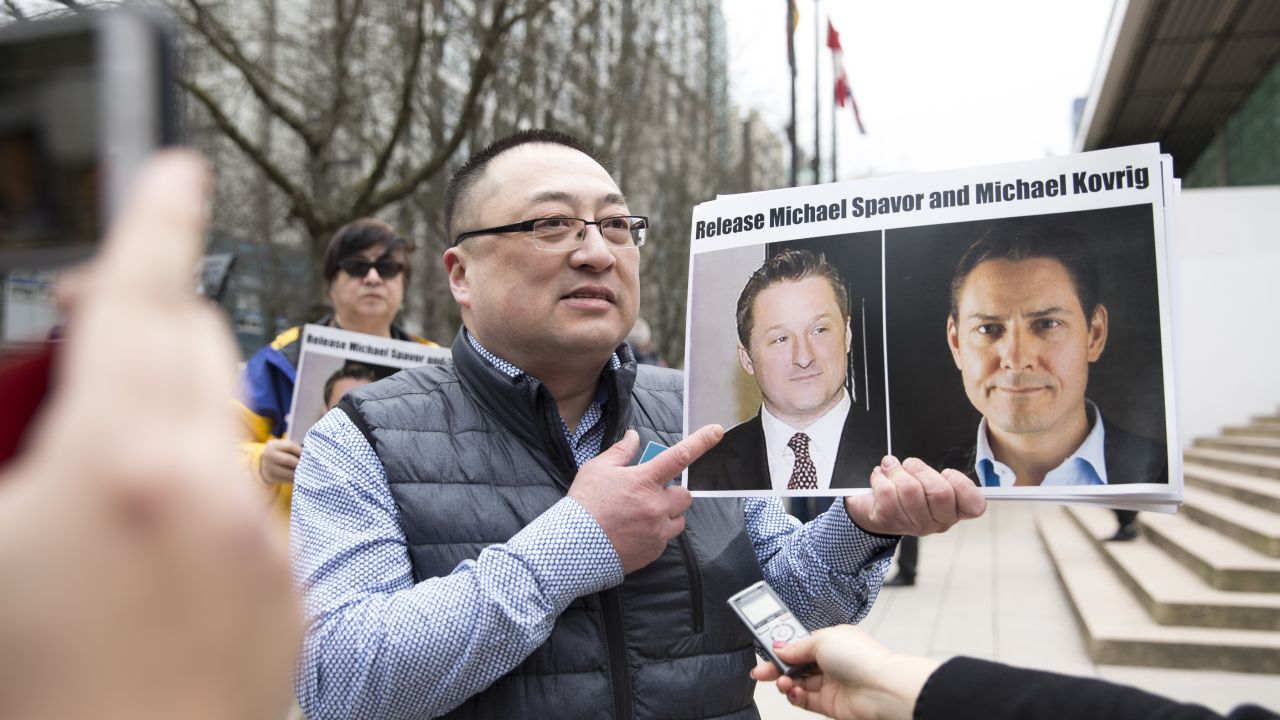 A protester holds photos of Canadians Michael Spavor and Michael Kovrig outside the British Columbia Supreme Court, in Vancouver, on March 6, 2019, as Huawei Chief Financial Officer Meng Wanzhou appeared in court.
