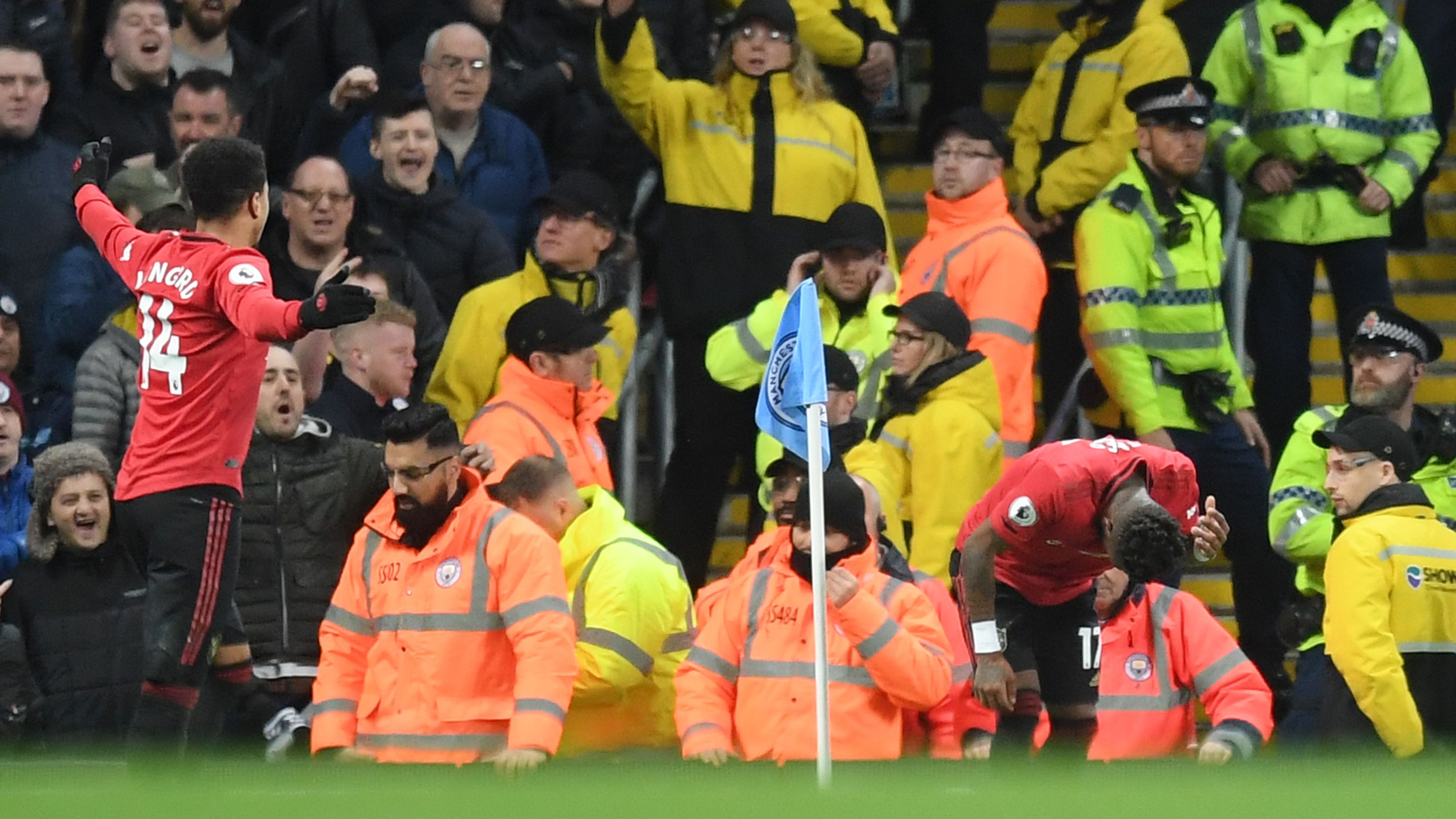 Fred of Manchester United reacts after being struck by an item thrown by Manchester City fans.
