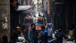 TOPSHOT - A Delhi Fire Service truck is seen along a street near the site of a facotry where a fire broke out, in Anaj Mandi area of New Delhi on December 8, 2019. - At least 43 people have died in a factory fire in India's capital New Delhi, with the toll still expected to rise, police told AFP on December 8. The blaze broke out in the early hours in the city's old quarter, whose narrow and congested lanes are lined with many small manufacturing and storage units. (Photo by STR / AFP) (Photo by STR/AFP via Getty Images)