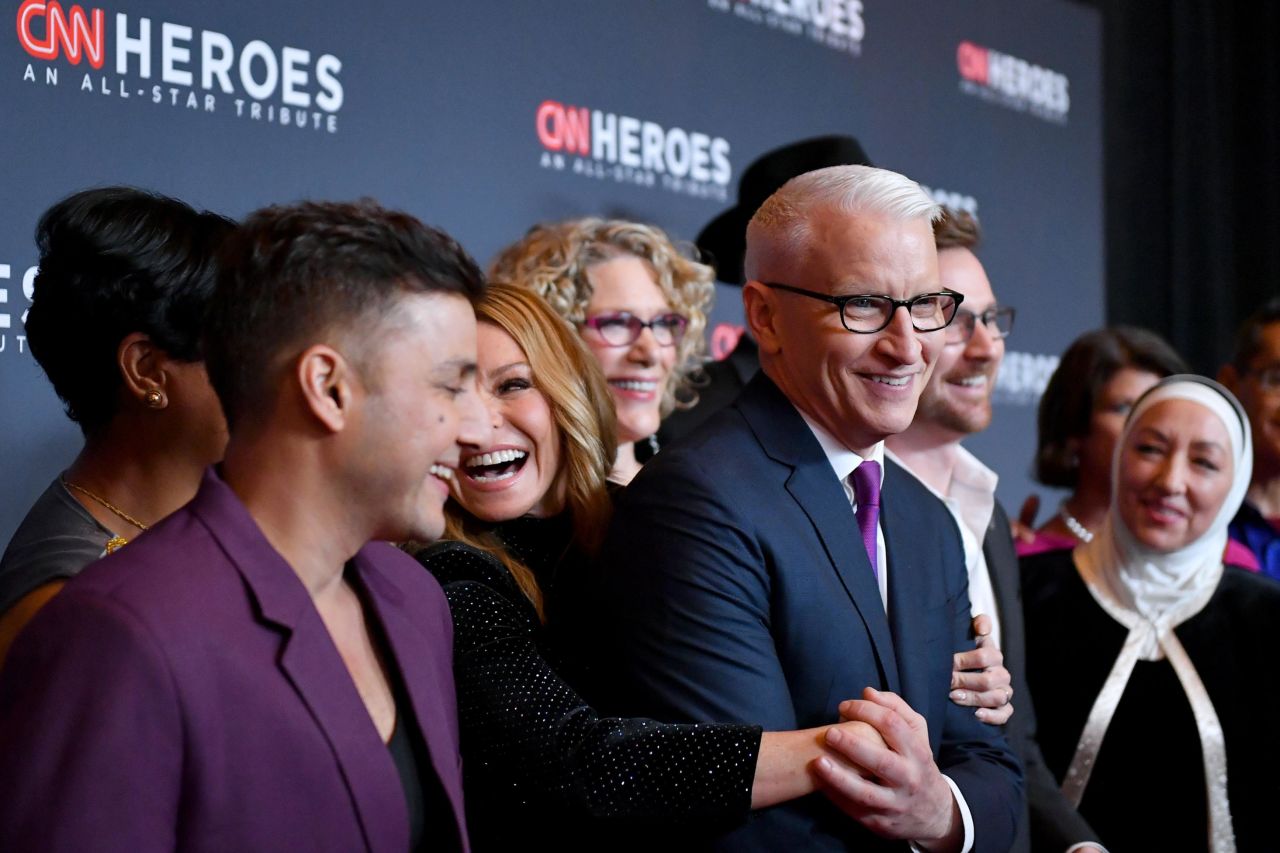 Hosts Kelly Ripa and Anderson Cooper laugh with the 2019 Top 10 CNN Heroes  on the red carpet prior to CNN Heroes: An All-Star Tribute.
